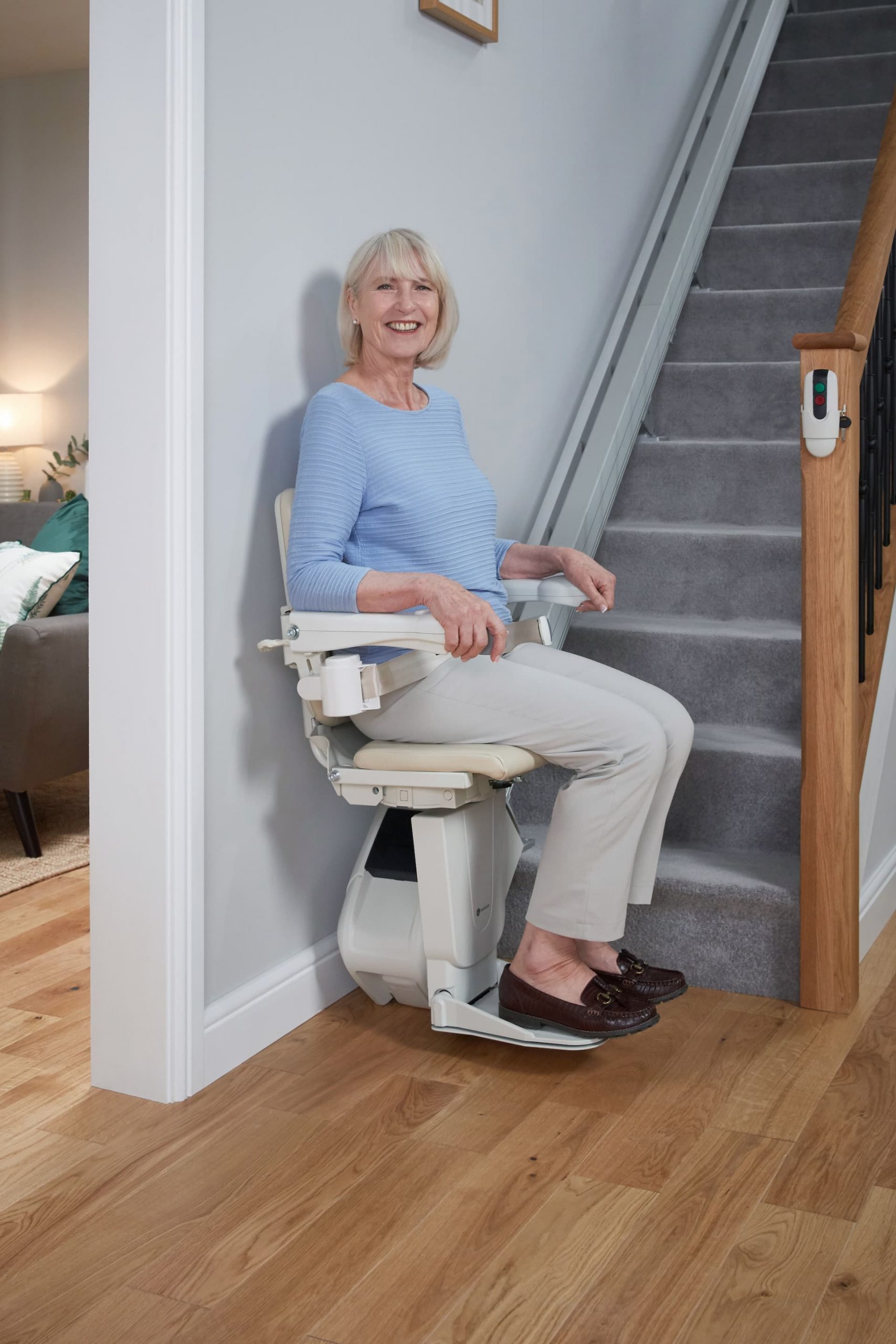 Femme assise sur un monte-escalier en rez-de-chaussé