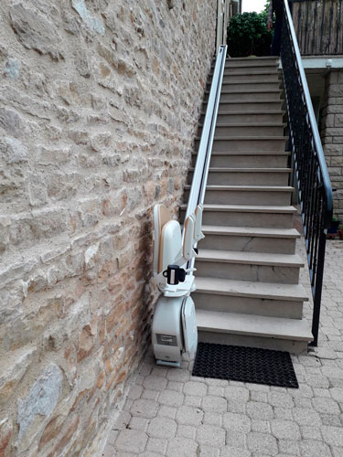 Siège monte-escalier replié au niveau bas. Faible encombrement.