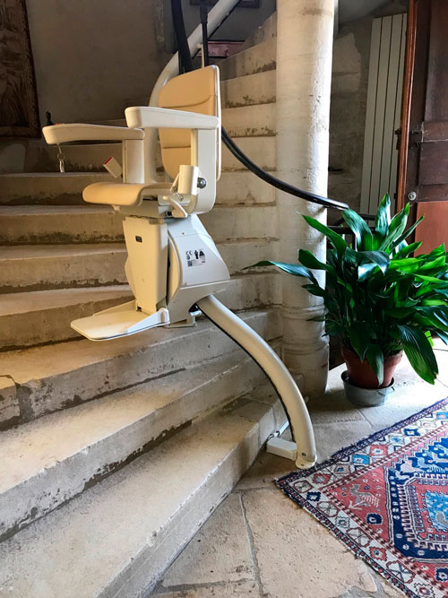 Siège monte escalier sur un escalier tournant en pierre dans l'Ain (01)